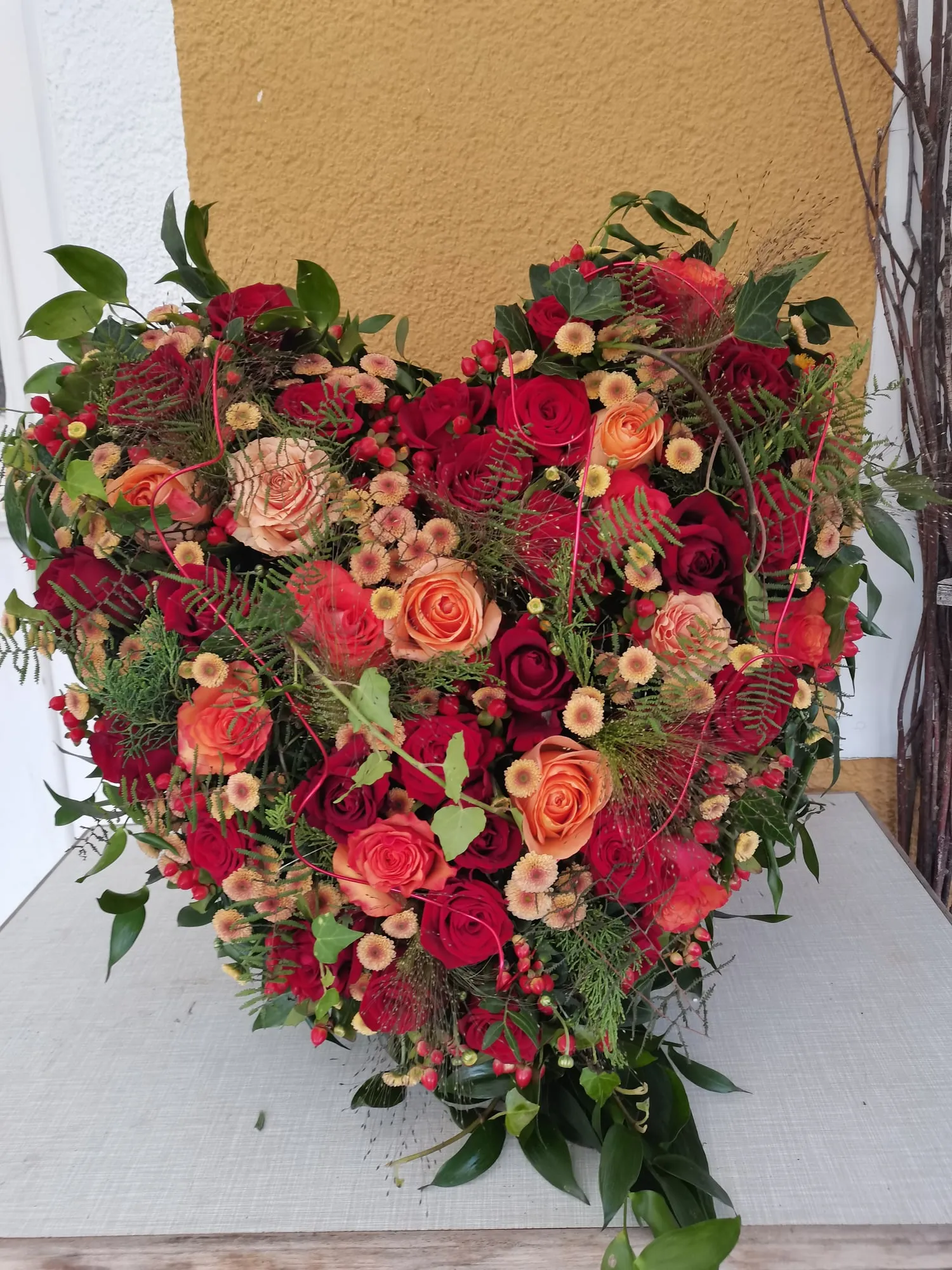 Herz in Rot und Orange mit Rosen und Nadelgrün