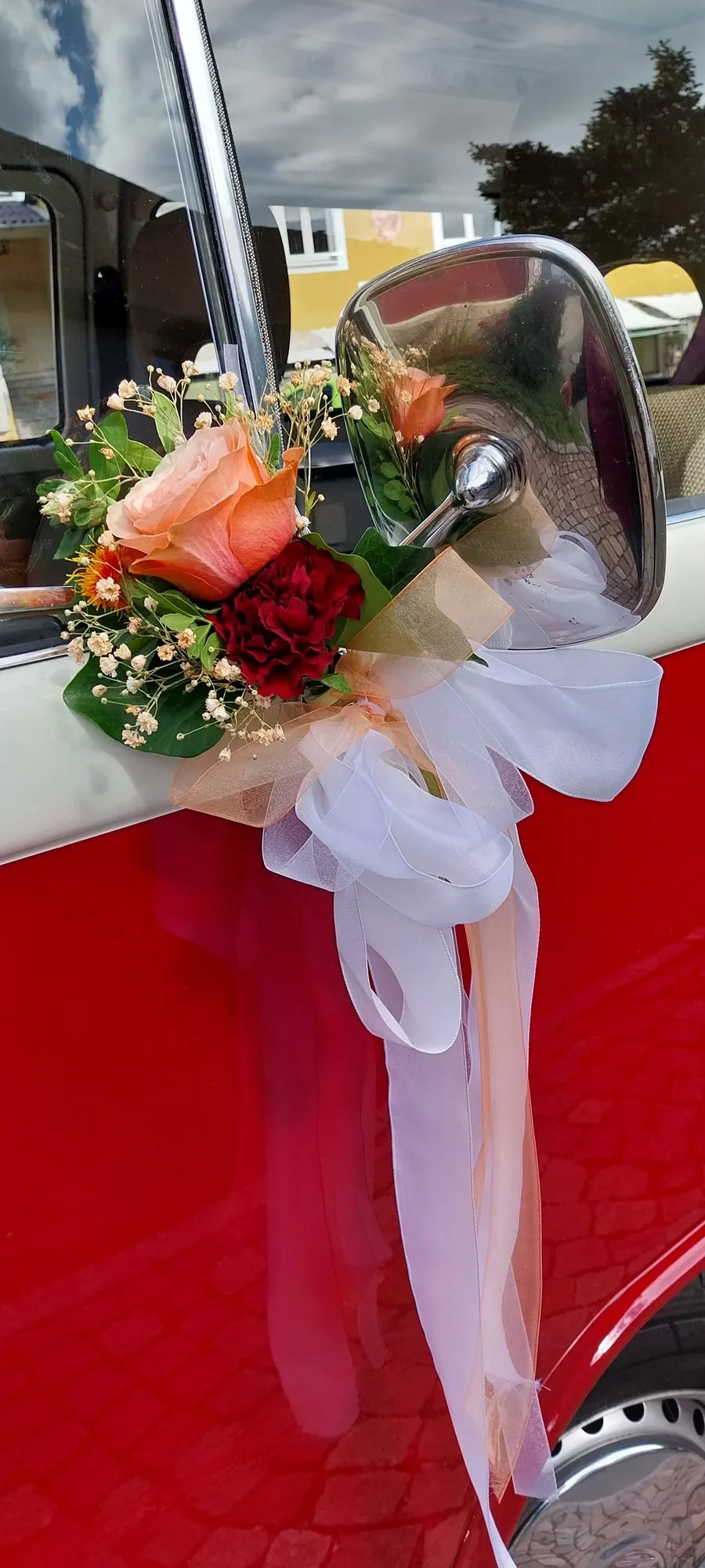 Autoschmuck aus lachsfarbenen Rosen mit weißem Organzaband