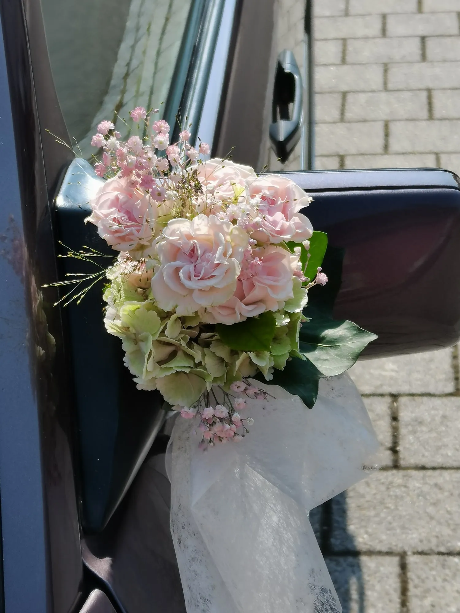 Strauß in Rosa und Weiß am Türgriff eines Autos