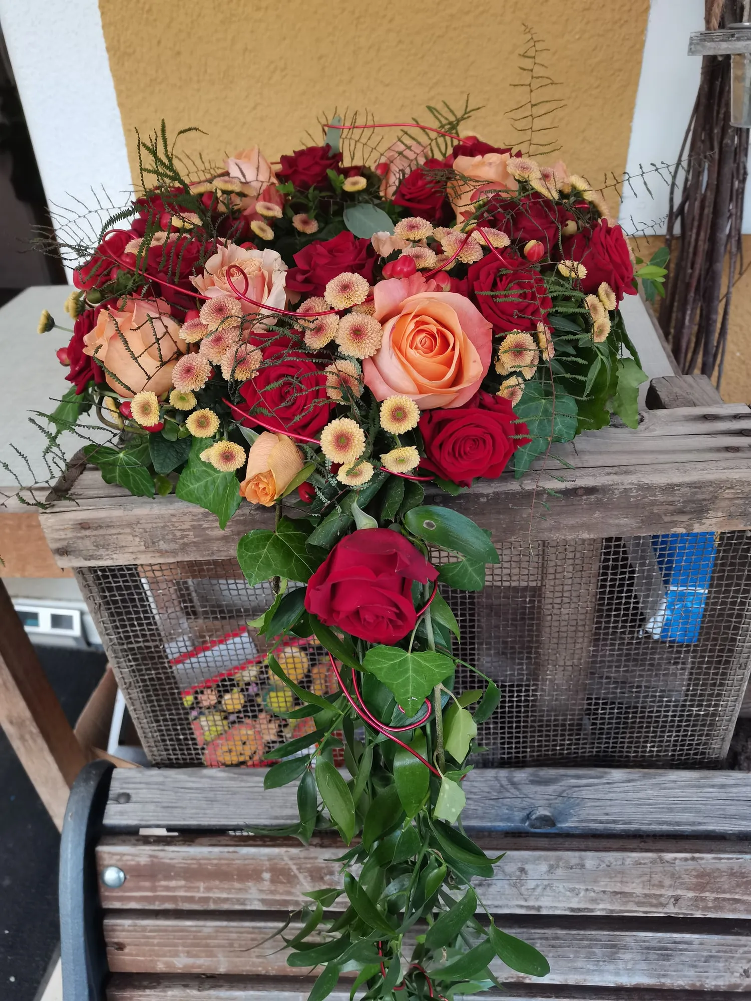Strauß aus lachsfarbenen und roten Rosen