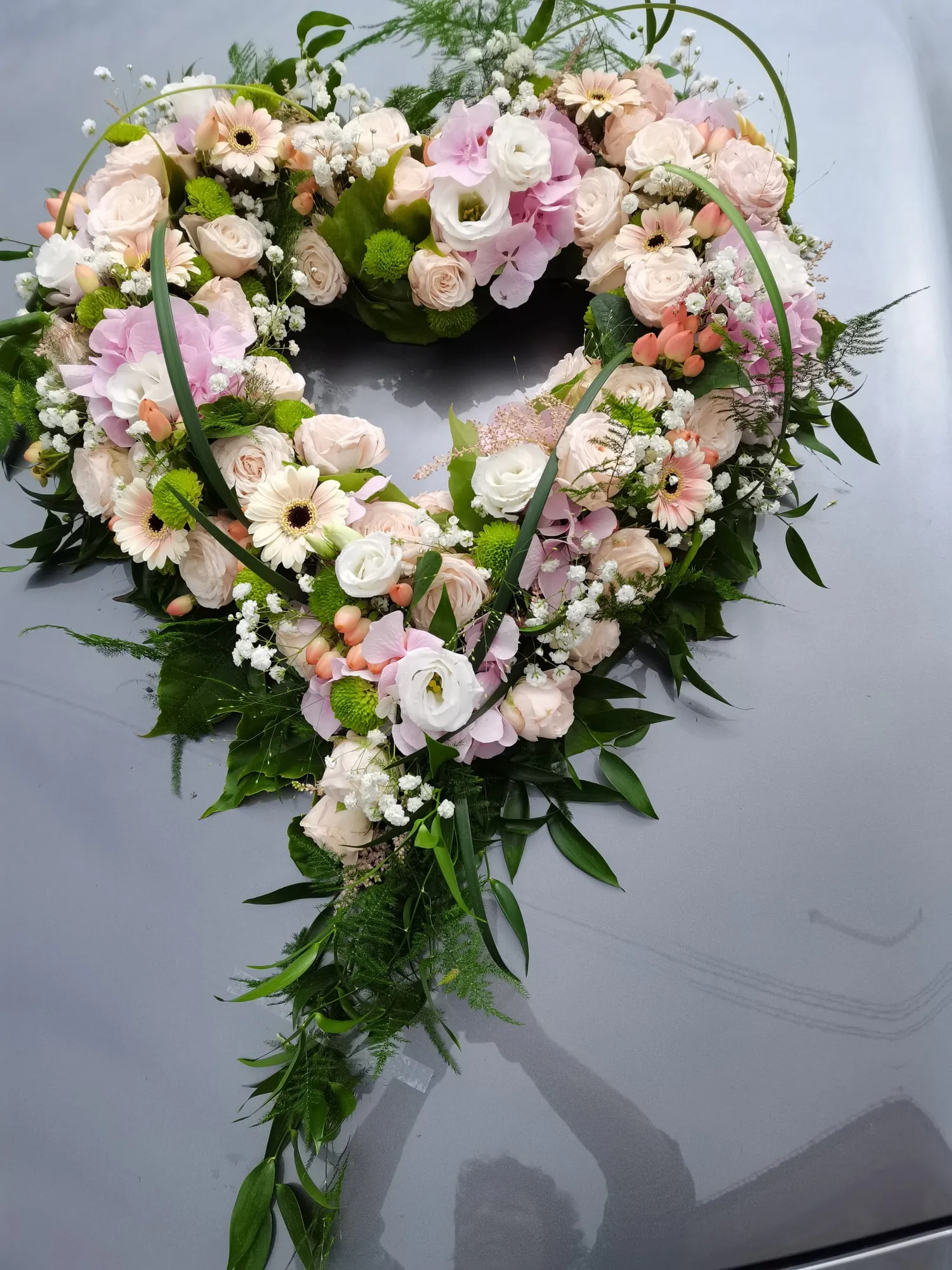 Herz aus cremefarbenen Rosen und Ranunkeln